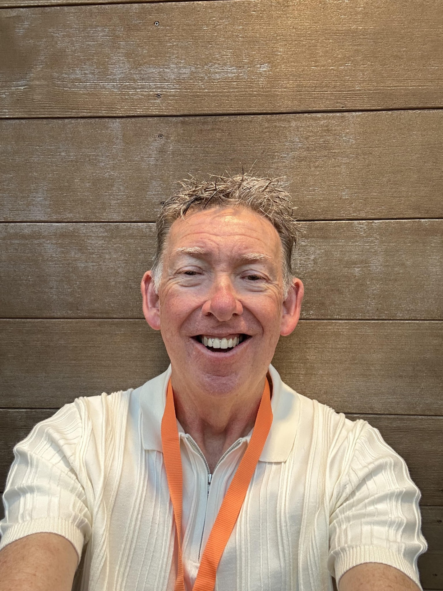 Geoff smiling in front of a timber wall