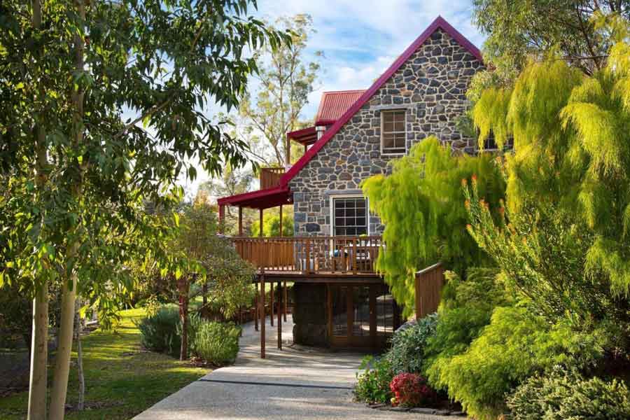 Bluegums Retreat's stone house and red roof among the gums